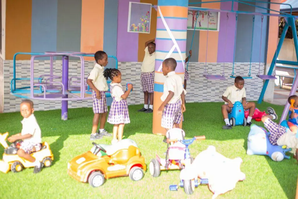 Kindergarten pupils on ride-on toys in the play area