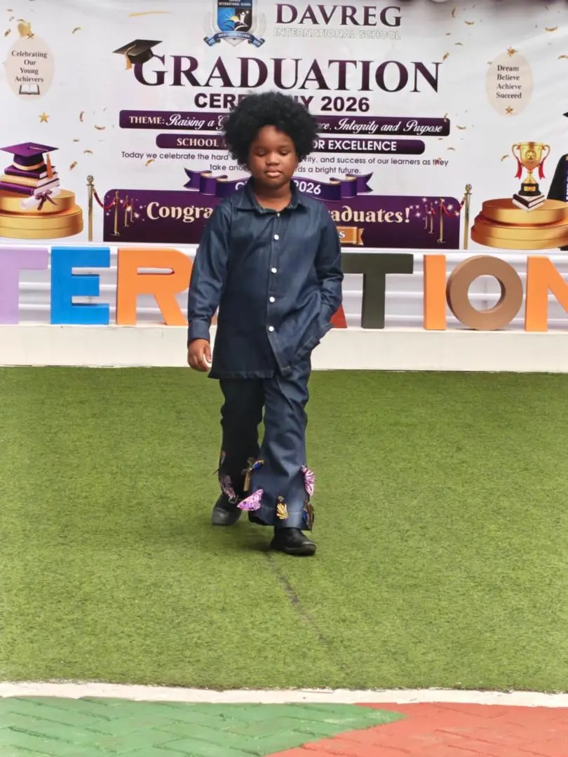 A pupil in a denim outfit with embroidered flared trousers walking the runway
