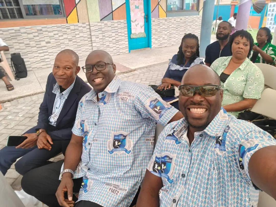 DavReg staff in matching school shirts seated among guests at the graduation